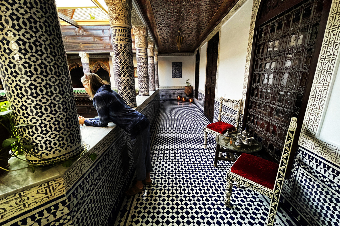 Fez Morocco Tours Riad Interior with Woman Peering Over Balcony